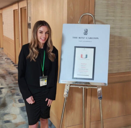 Toni at Miami Conference w banner